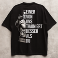 EINER VON UNS TRAINIERT BESSER ALS DU Unisex Oversized Shirt (Backprint)